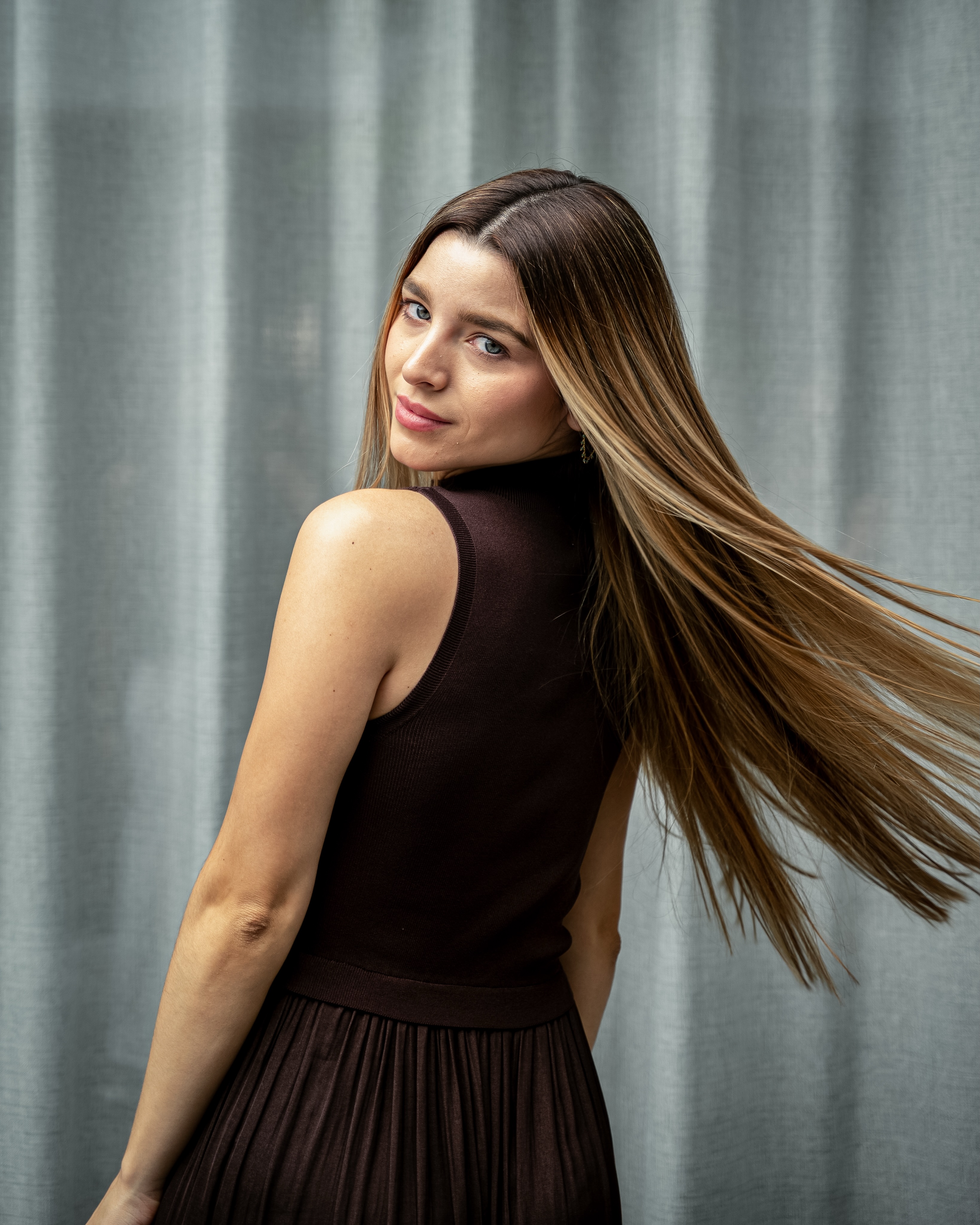Estilista dando forma al cabello de una clienta en un salón luminoso